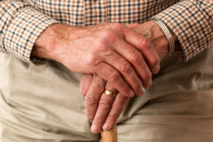 A senior person holding a stick.