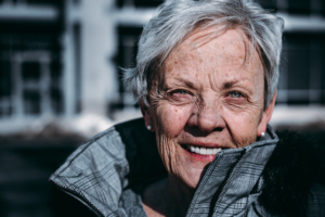 an older adult wearing a grey jacket