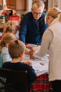 an elderly man making a dessert with family members