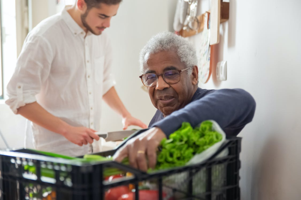 A senior taking groceries out of a basket