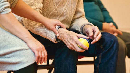 an elderly man holding a ball.