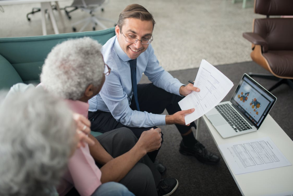 A senior couple and senior living advisor discussing a document