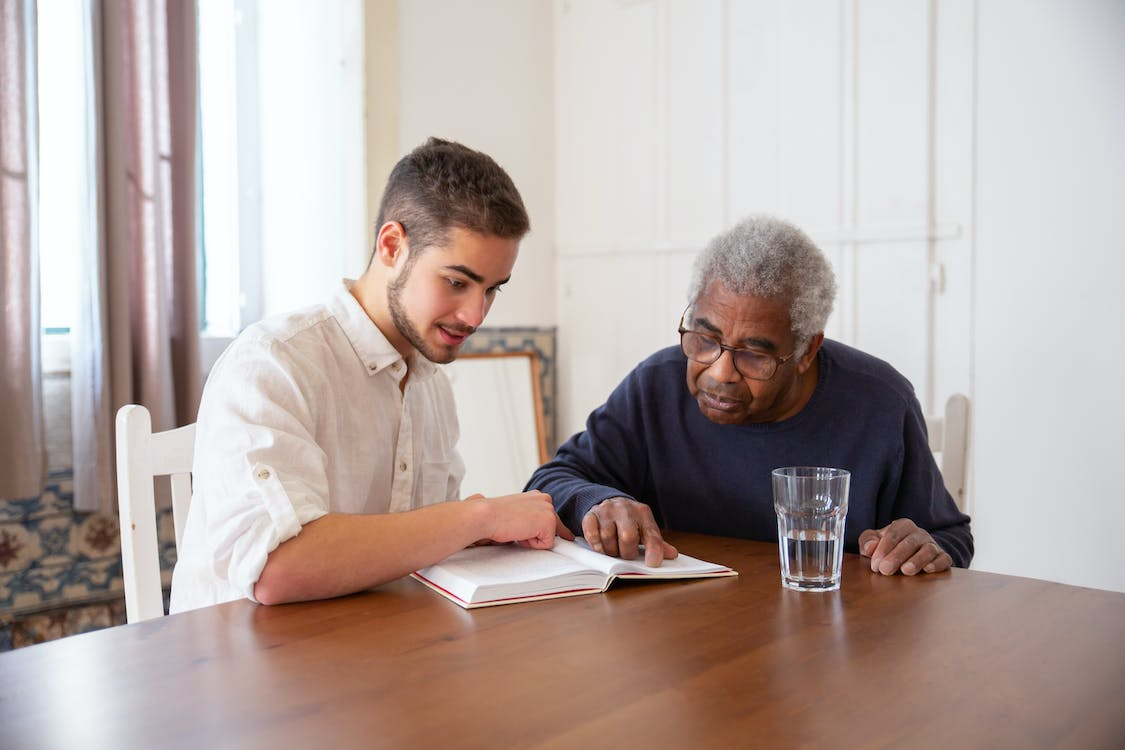 A senior sitting with their caregiver