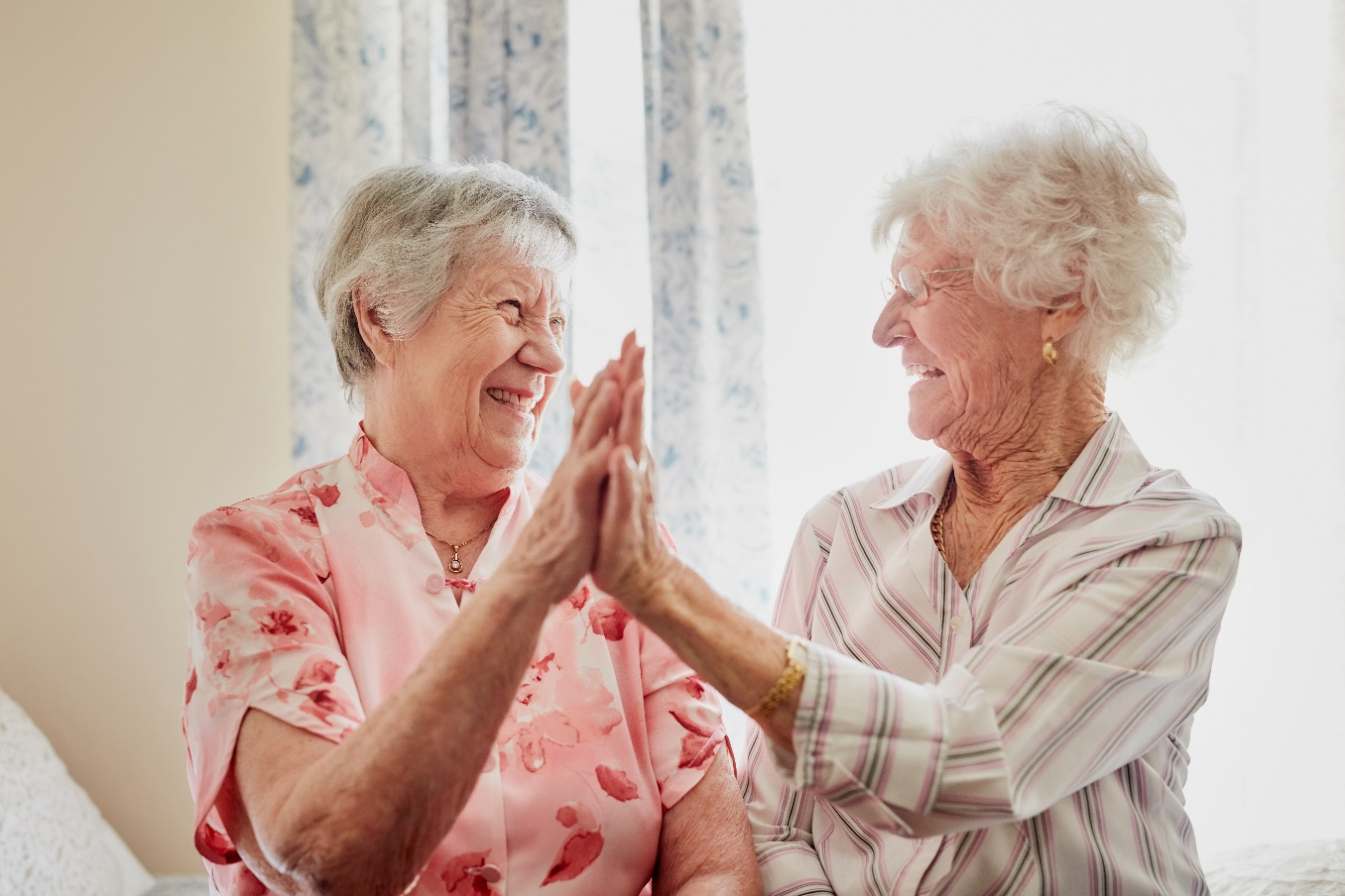 Pair of senior friends high fiving