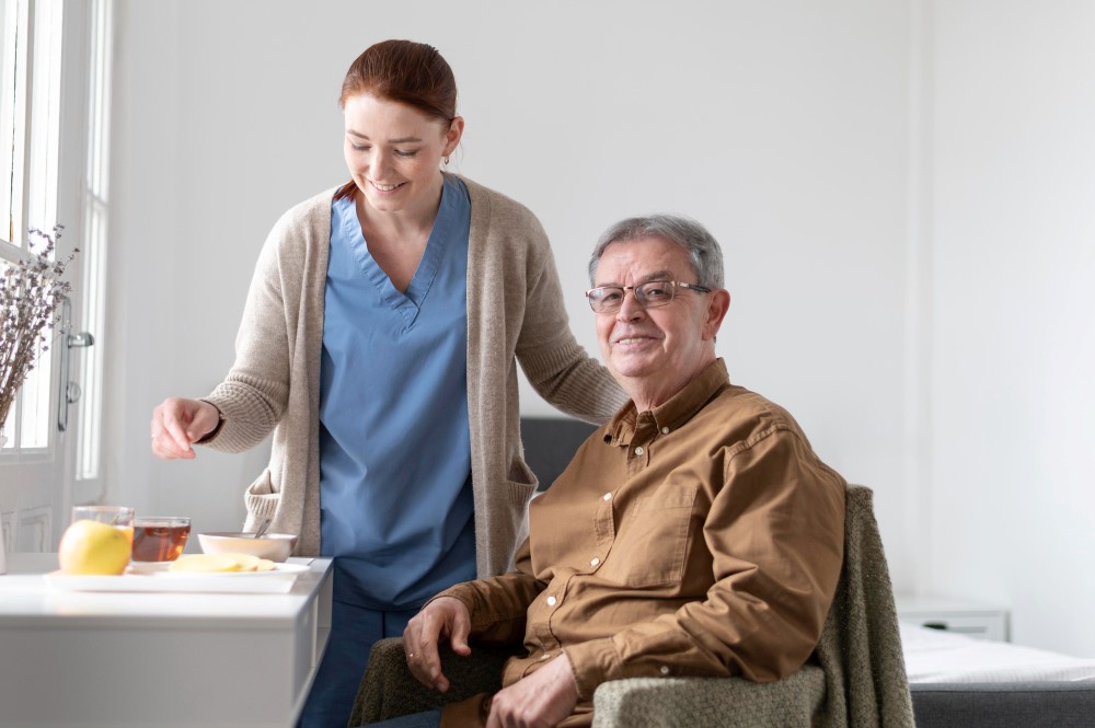 A caregiver helping a senior resident have breakfast