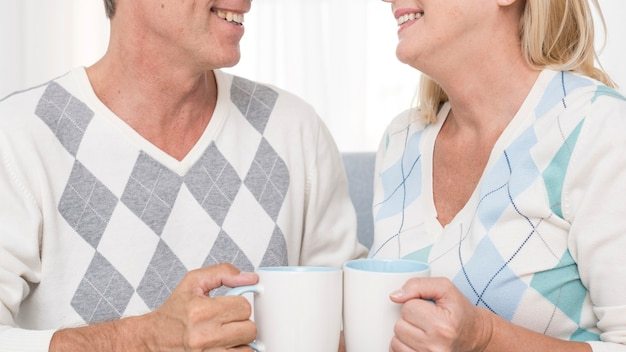 A senior couple holding mugs