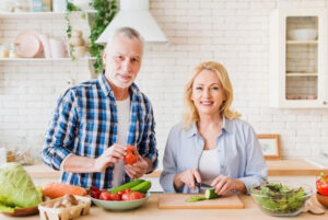 A senior couple cutting fruits and vegetables