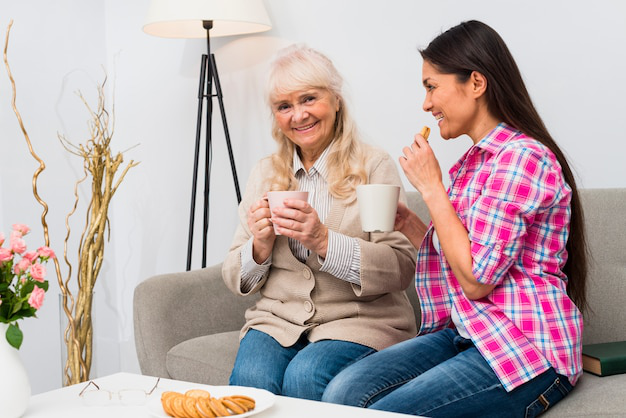 A senior having cookies and tea with their caregiver