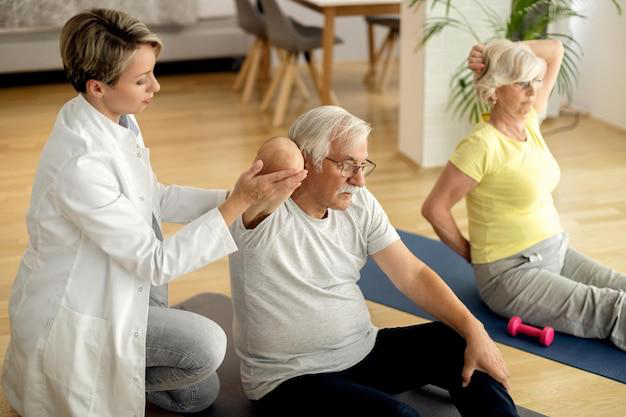 A senior couple doing stretches with the help of a professional