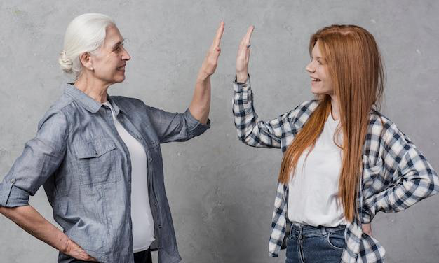 A senior high fiving a younger individual