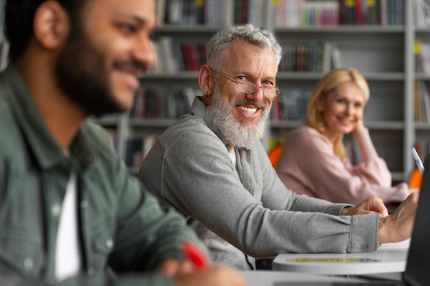 A senior smiling while seated in a class with other continuing learners