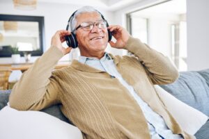 A senior listening to music through headphones