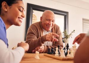 A senior playing chess with community members